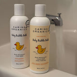 Two bottles of Carina Organics baby bubble bath on a bathroom counter.